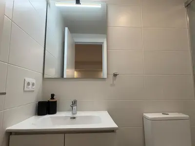 a bathroom with a sink and a mirror and a toilet at Villa Leonardo in Castelldefels