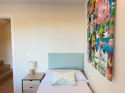 a bedroom with a bed with a painting on the wall at Villa Leonardo in Castelldefels