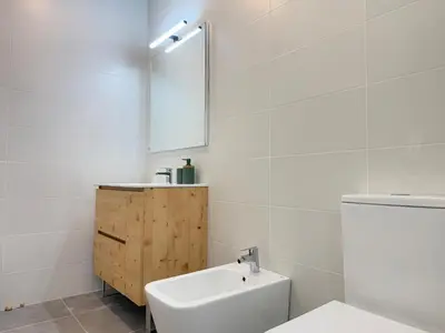 a bathroom with a white toilet and a sink at Villa Leonardo in Castelldefels