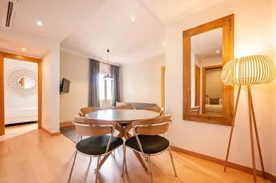 a dining room with a table and chairs and a mirror at Sweett - Vicky Barcelona in Barcelona