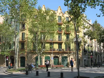 a large yellow building with people walking in front of it at Playa Beach Barcelonastuff Apartments in Barcelona