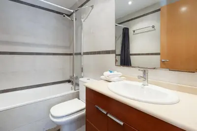a bathroom with a sink and a toilet and a mirror at Playa Beach Barcelonastuff Apartments in Barcelona
