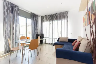 a living room with a blue couch and a table at Playa Beach Barcelonastuff Apartments in Barcelona