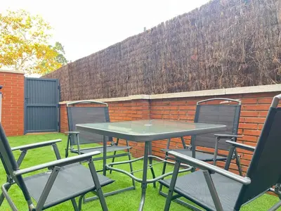 a picnic table and chairs in front of a brick wall at Beautiful renovated studio in Castelldefels