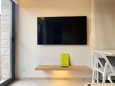 a yellow book sitting on a wooden bench next to a tv at Beautiful renovated studio in Castelldefels