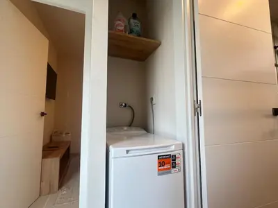 a small kitchen with a white refrigerator in a room at Beautiful renovated studio in Castelldefels