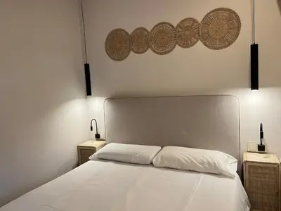 a bedroom with a white bed with two night stands at Beautiful renovated studio in Castelldefels
