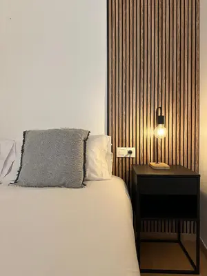 a bedroom with a bed with a side table and a lamp at Spacious home in Bonanova in Barcelona