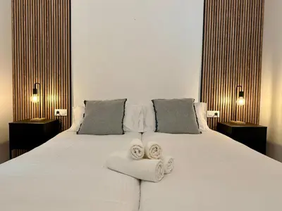 a bedroom with a large white bed with towels on it at Spacious home in Bonanova in Barcelona