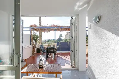 a room with a door open to a patio with a table at AIGUADOLÇ APARTMENT in Sitges
