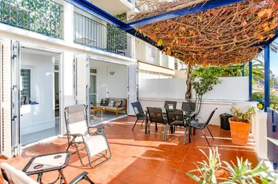 an outdoor patio with chairs and tables at AIGUADOLÇ APARTMENT in Sitges