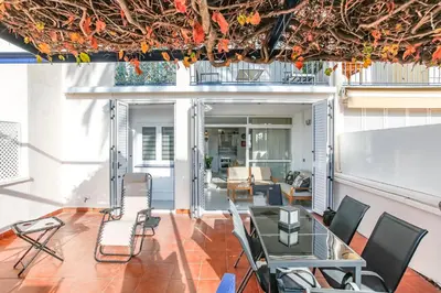 a room with a glass table and chairs on a balcony at AIGUADOLÇ APARTMENT in Sitges