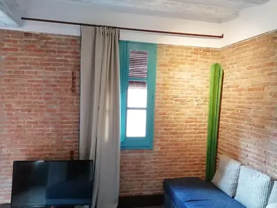 a living room with a blue couch and a window at Beachfront apartment Barceloneta Street in Barcelona