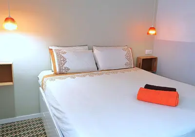 a bedroom with a white bed with an orange bag on it at Entire Flat First Beach line - Sea Views - Vilanova i Geltru in Vilanova i la Geltrú