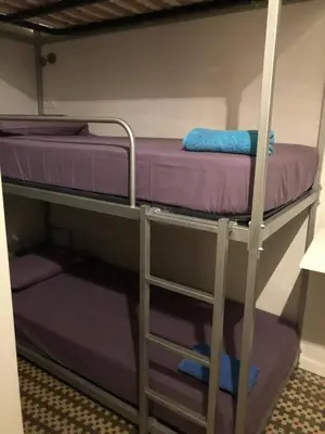 two bunk beds in a room with purple sheets at Entire Flat First Beach line - Sea Views - Vilanova i Geltru in Vilanova i la Geltrú