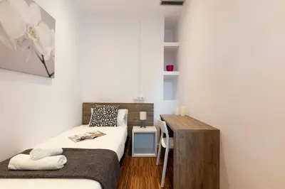 a small bedroom with a bed and a desk at 2905 - AB Comte dUrgell I-II in Barcelona