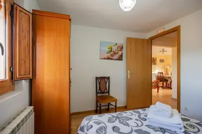 a bedroom with a bed and a door to a living room at Mas Prat in Pla del Panadés