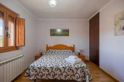 a bedroom with a bed with a black and white comforter at Mas Prat in Pla del Panadés