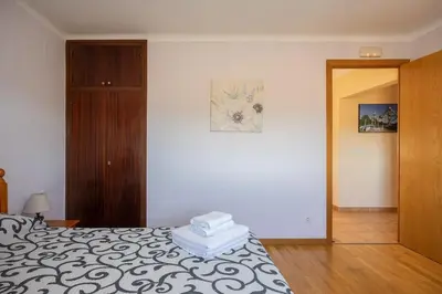 a bedroom with a bed and a wooden cabinet at Mas Prat in Pla del Panadés