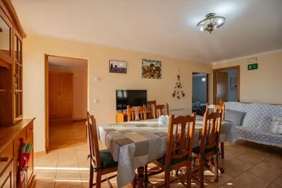 a dining room and living room with a table and chairs at Mas Prat in Pla del Panadés