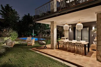 a patio with a table and chairs in a yard at Chez Pablo Barcelona in Cabrils