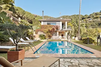 a villa with a swimming pool in front of a house at Chez Pablo Barcelona in Cabrils