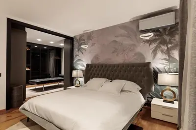 a bedroom with a large white bed with a wall at Chez Pablo Barcelona in Cabrils