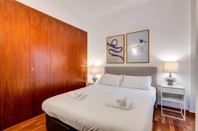 a bedroom with a large white bed with two towels on it at Acogedor apartamento en el corazón de Sant Antoni in Barcelona