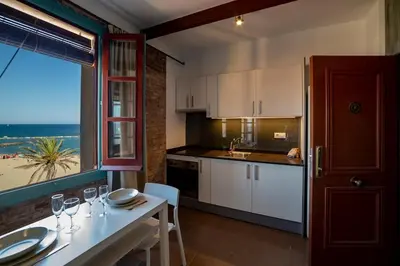 a kitchen with a table and a view of the beach at Beach apartment with sea views in Barcelona