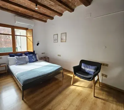 a bedroom with a bed and a chair in it at Flat with 2 rooms and private terrace min 32 days in Barcelona