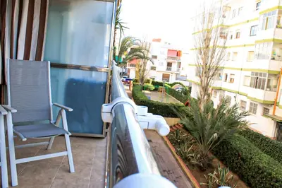 a chair on a balcony with a view of a street at Apartamento Sitges Can Robert in Sitges