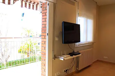 a room with a flat screen tv and a window at Apartamento Sitges Can Robert in Sitges