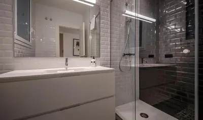 a bathroom with a sink and a glass shower at Apartamento de cuatro dormitorios en Carrer Diputació in Barcelona