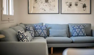 a blue couch in a living room with pillows on it at Apartamento de cuatro dormitorios en Carrer Diputació in Barcelona