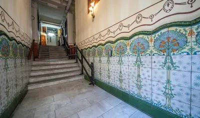 a hallway with tiled walls and stairs in a building at Apartamento de cuatro dormitorios en Carrer Diputació in Barcelona