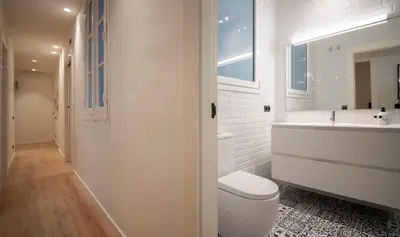a white bathroom with a toilet and a sink at Apartamento de cuatro dormitorios en Carrer Diputació in Barcelona