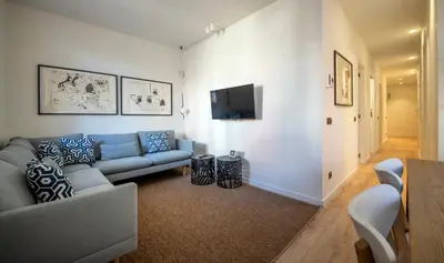 a living room with a couch and a flat screen tv at Apartamento de cuatro dormitorios en Carrer Diputació in Barcelona