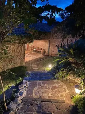 a stone pathway with a bench in a garden at night at Villa Juny Best view in North Barcelona Coast in Cabrils