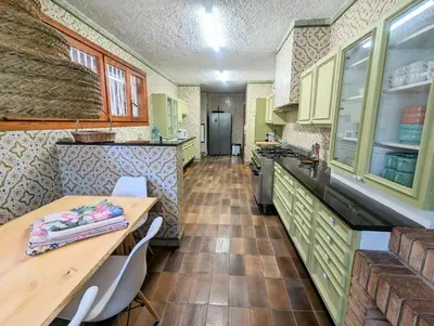 a kitchen with green cabinets and a wooden table at Villa Juny Best view in North Barcelona Coast in Cabrils