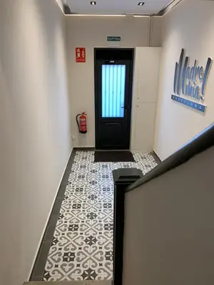 a hallway with a black door and a tile floor at MadreMia - Wow Hub Barcelona in Hospitalet de Llobregat