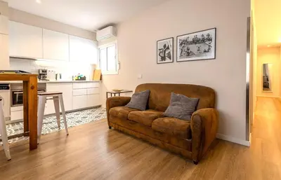 a living room with a couch and a kitchen at MadreMia - Wow Hub Barcelona in Hospitalet de Llobregat