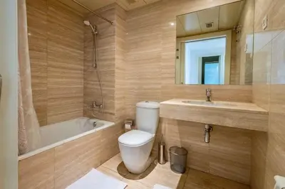 a bathroom with a toilet and a tub and a sink at Apartment for 6, spacious and bright in Bonanova in Barcelona