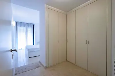 a white bedroom with white cabinets and a bed at Apartment for 6, spacious and bright in Bonanova in Barcelona