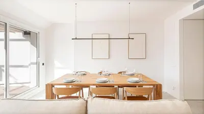 a dining room with a wooden table and chairs at Penthouse with Terrace near Gran Via and Camp Nou in Barcelona