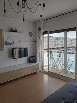 a living room with a flat screen tv and a balcony at La CASA BLAVA in Cubelles