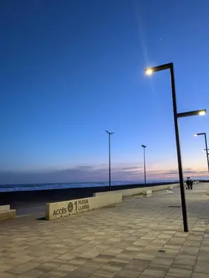 a street light next to the beach at dusk at La CASA BLAVA in Cubelles