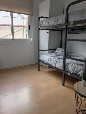 a room with two bunk beds and a table at La CASA BLAVA in Cubelles