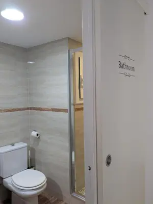 a bathroom with a toilet and a glass shower at La CASA BLAVA in Cubelles