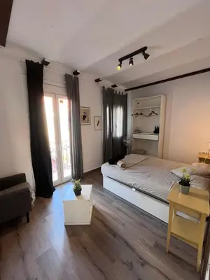 a bedroom with a large bed and a couch at Bright and cozy 2 rooms apartment in Hospitalet de Llobregat