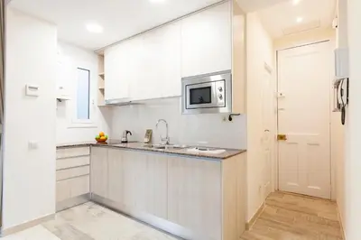 a white kitchen with a sink and a microwave at 2582 - AB Sagrada Familia Marina in Barcelona